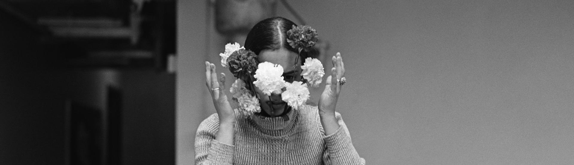 Ana Mendieta tient des fleurs devant son visage